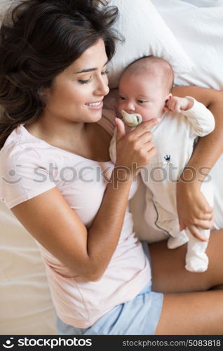 Young mother with her baby in bed