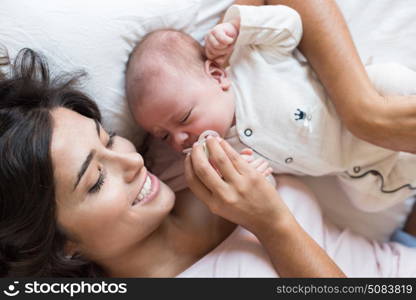 Young mother with her baby in bed