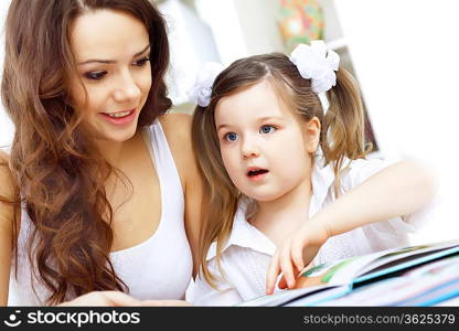 Young mother with little daughter studying at home