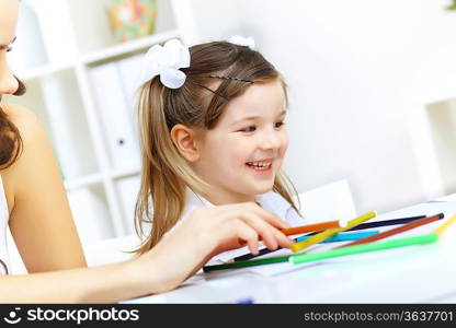 Young mother with little daughter studying at home