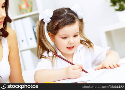 Young mother with little daughter studying at home