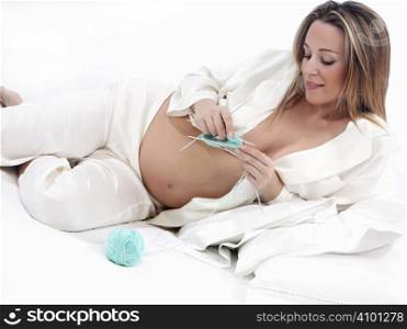 young mothers sits at home relaxing knitting for her new baby