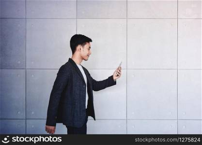Young motivation Businessman Reading Message via Smart Phone while Walk. Lifestyle of Modern Male, Technology to Communicate in Business concept