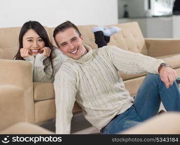 Young multiethnic couple relaxing on the sofa at luxury living room