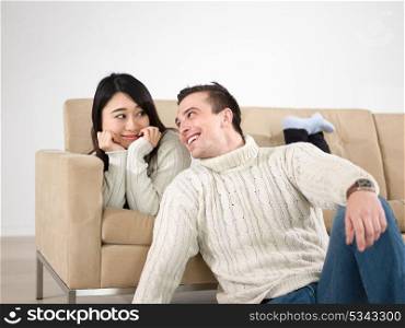 Young multiethnic couple relaxing on the sofa at luxury living room