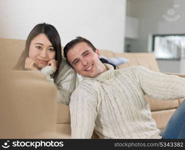 Young multiethnic couple relaxing on the sofa at luxury living room