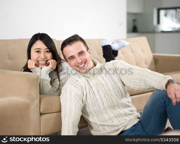 Young multiethnic couple relaxing on the sofa at luxury living room