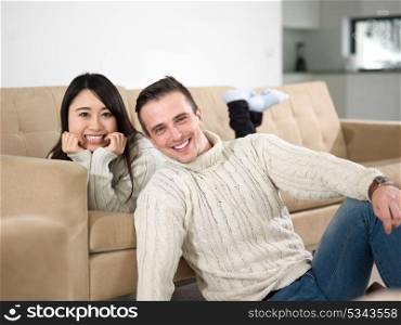 Young multiethnic couple relaxing on the sofa at luxury living room