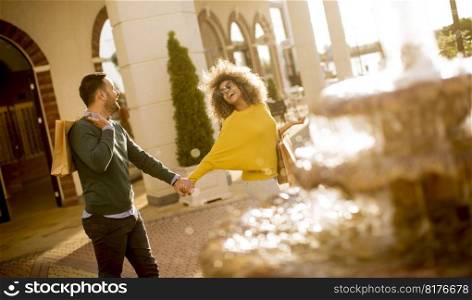 Young multiethnic couple walking by the fountain on a sunny day