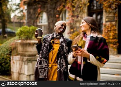 Young multiracial friends walking around the town, talking and carry coffee to go in the hands