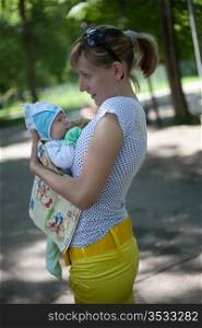 Young mum in park with the small child on hands