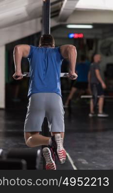 young muscular bodybuilder working out in gym doing exercises parallel bars Concept sport