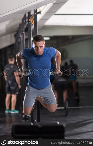 young muscular bodybuilder working out in gym doing exercises parallel bars Concept sport