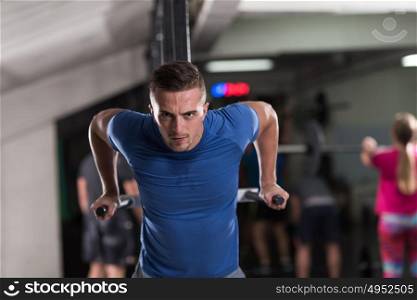 young muscular bodybuilder working out in gym doing exercises parallel bars Concept sport