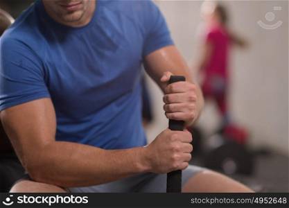 young muscular man after workout at gym with hammer and tractor tire with a focus on hands