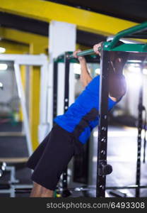 young muscular man doing pull ups on the horizontal bar as part of Crossfitness Training. man doing pull ups on the horizontal bar