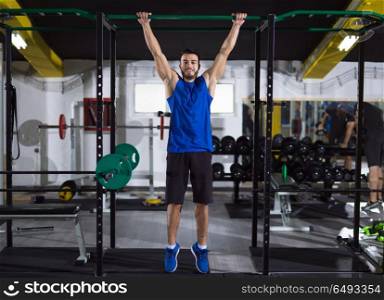 young muscular man doing pull ups on the horizontal bar as part of Crossfitness Training. man doing pull ups on the horizontal bar