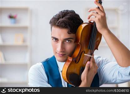 Young musician man practicing playing violin at home