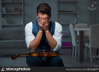 Young musician man practicing playing violin at home