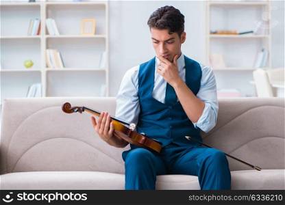 Young musician man practicing playing violin at home. The young musician man practicing playing violin at home