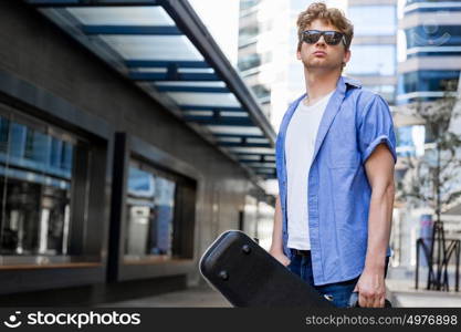 Young musician with guitar in city. Portrait of young musician with guitar in city