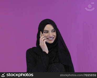 Young muslim businesswoman in traditional clothes or abaya using smartphone. Arab woman representing techology, islamic  fashion and Ramadan kareem concept