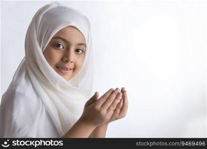 Young Muslim girl wearing hijab and praying 