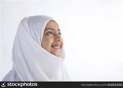 Young Muslim girl wearing hijab looking away and smiling
