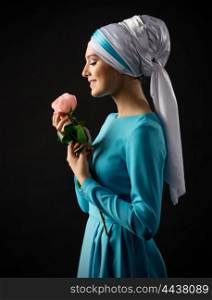Young muslim girl with rose on grey