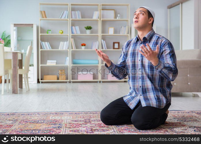 Young muslim man praying at home