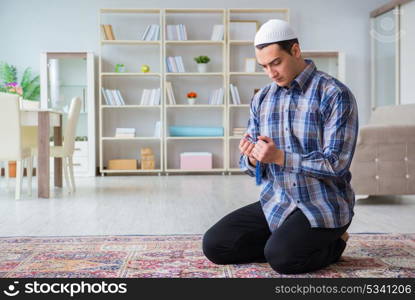 Young muslim man praying at home