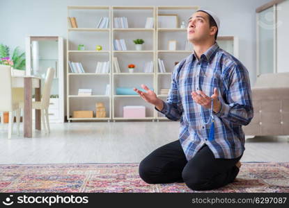 Young muslim man praying at home