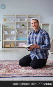 Young muslim man praying at home