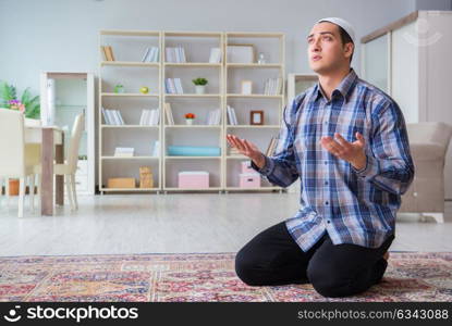 Young muslim man praying at home. The young muslim man praying at home
