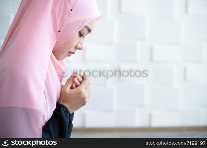 Young muslim woman holding prayer beads over mosque background
