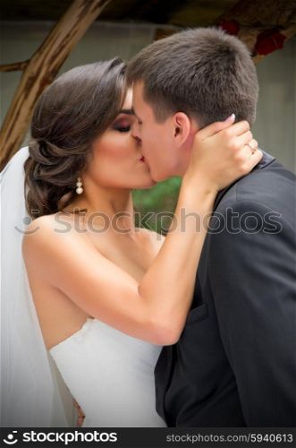 Young newlyweds kissing and summer day