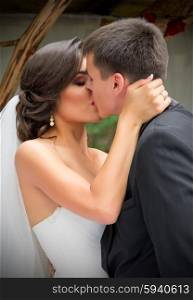 Young newlyweds kissing and summer day