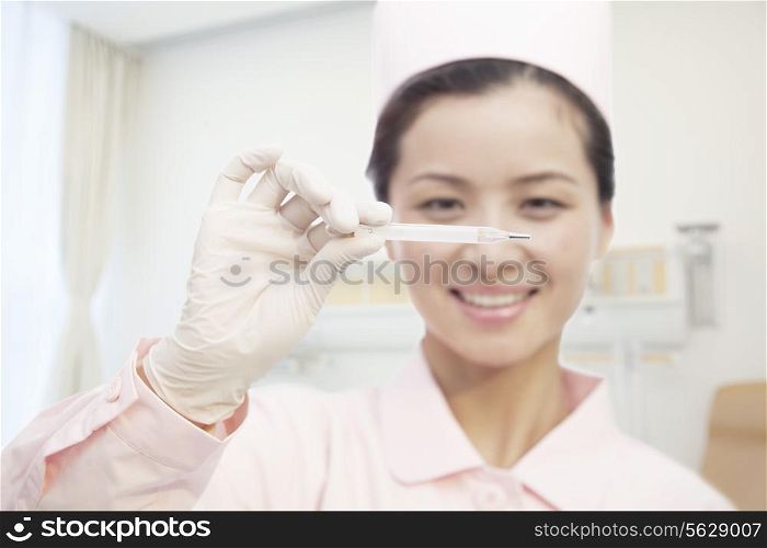 Young Nurse Holding Thermometer, Close-Up
