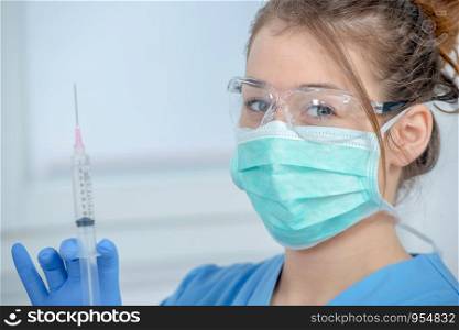 young nurse preparing injection with a syringe in hospital