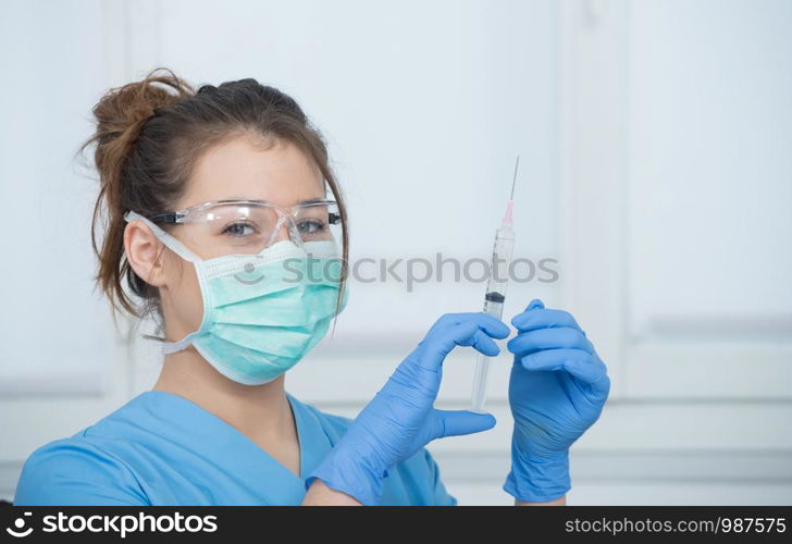 young nurse preparing injection with a syringe in hospital