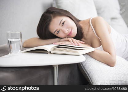 Young oriental woman reading at home