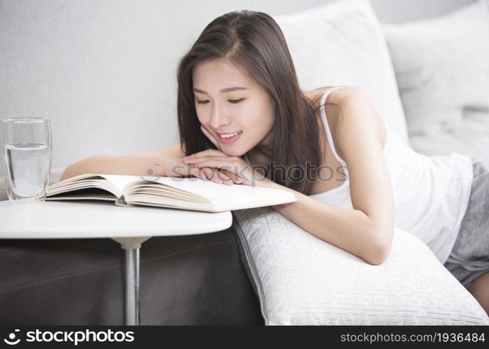 Young oriental woman reading at home