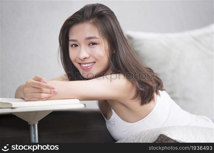 Young oriental woman reading at home