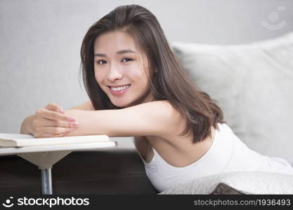 Young oriental woman reading at home