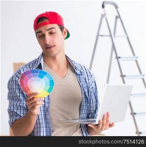 Young painter contractor choosing colors for home renovation. The young painter contractor choosing colors for home renovation