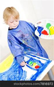 Young painter working on a painting with poster paint, coloring a traffic light