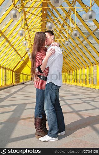 young pair kisses on footbridge