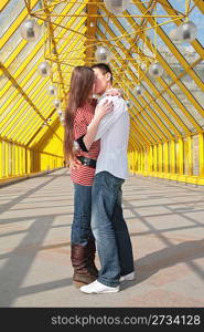 young pair kisses on footbridge