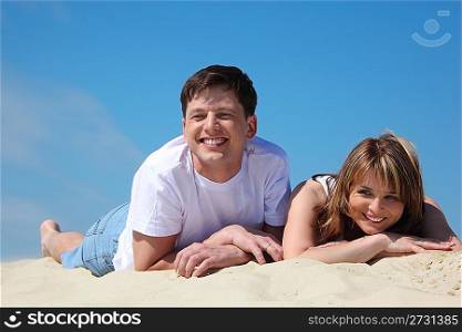 young pair lies on sand
