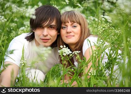 young pair sits in grass